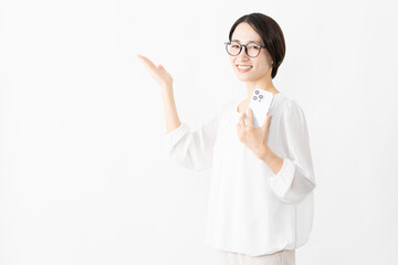 Fototapeta premium スマートフォンを使うメガネをかけたカットソー姿の女性 ライフスタイルイメージ