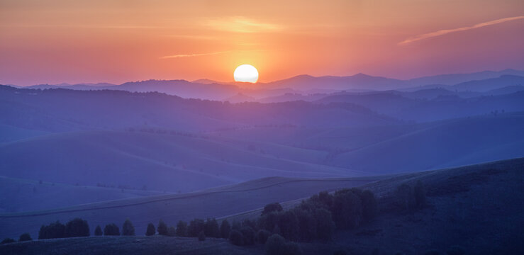 Picturesque sunset in the countryside, hills on the horizon
