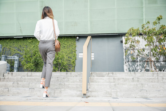 In the morning rush to the office, a businesswoman legs in motion take center stage on stairway. This closeup reflects dedication to progress, ambition and relentless effort of a modern manager.