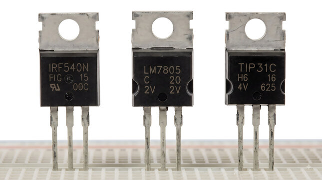 Electronic Components in TO-220 Packages on Breadboard: IRF540N MOSFET, LM7805 Voltage Regulator, and TIP31C Transistor Isolated on White