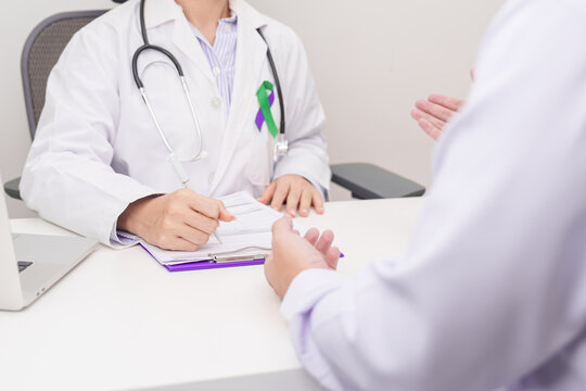 Doctor and patient having a medical consultation for purple and green ribbon concept of March Anal Cancer Awareness month, Colorectal and Colon Cancer, Healthcare and February world cancer day