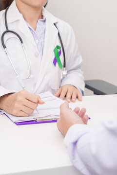 Doctor and patient having a medical consultation for purple and green ribbon concept of March Anal Cancer Awareness month, Colorectal and Colon Cancer, Healthcare and February world cancer day