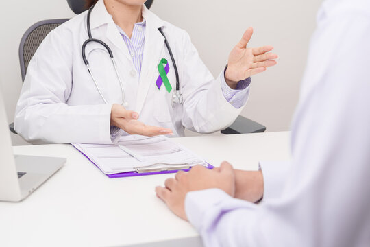 Doctor and patient having a medical consultation for purple and green ribbon concept of March Anal Cancer Awareness month, Colorectal and Colon Cancer, Healthcare and February world cancer day