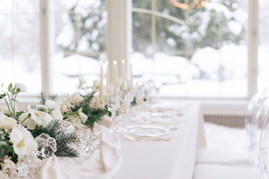 Luxurious white Christmas wedding table decoration with flowers and winter theme