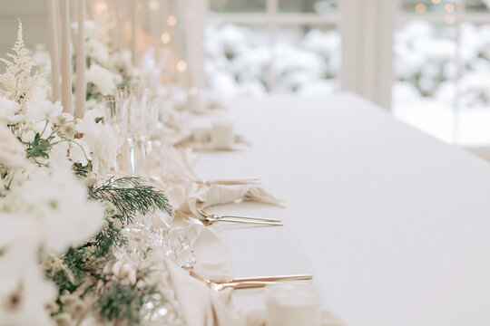 Luxury white Christmas wedding table setting with candles and winter flowers