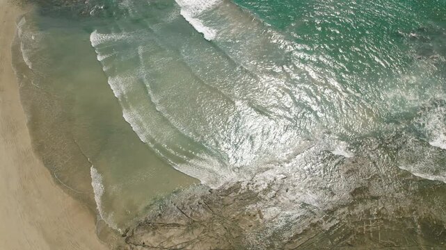 Aerial view of Ostional beach in Costa Rica showing gentle ocean waves and sandy shore