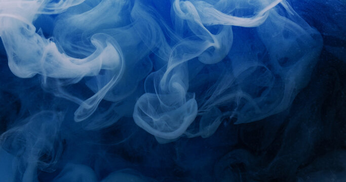 Color mist. Paint splash. Defocused blue underwater vapor liquid glitter water bright texture spreading on black abstract vibrant art background.