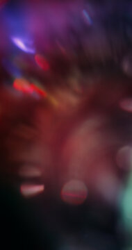 Blur ray. Rainbow glint. Defocused pink blue purple colorful radiant neon optical round texture on illuminated dark black abstract bokeh light background.