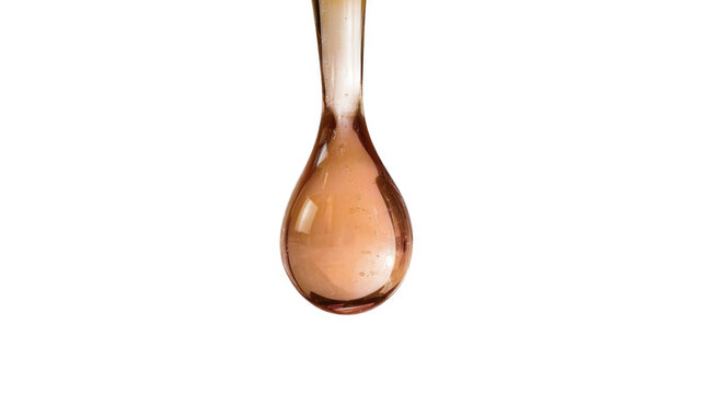 Close-up shot of a single golden liquid drop suspended from a spoon against a plain transparent background.