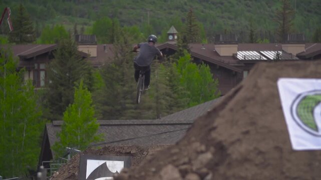 BMX rider catching air in the mountains off of dirt jumps