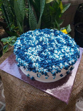 Beautifully decorated cake with blue hydrangea-inspired buttercream icing texture set against a natural background
