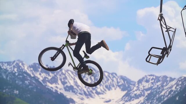 Slow motion close up of Mountain bike rider doing tricks in the air