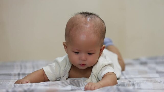 Baby infant child lying on bed in white shirt, cute adorable Asian toddler indoors, soft blanket, innocence, childhood, newborn, healthy, happy, cozy home, peaceful, curious, calm, sweet expression