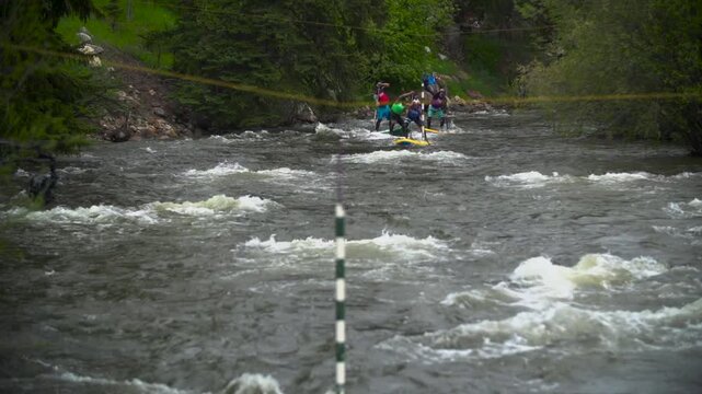 Stand up paddle boarders racing down the river in the mountains