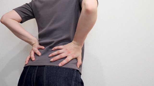 両手を腰に手を当てる女性の後ろ姿