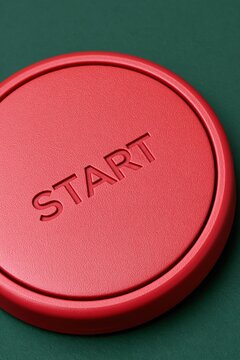 Close up of red start button on green