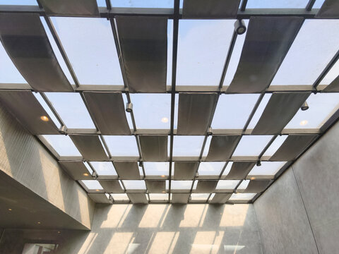 Modern architectural skylight roof with overlapping rectangular panels, natural daylight filtering through grid