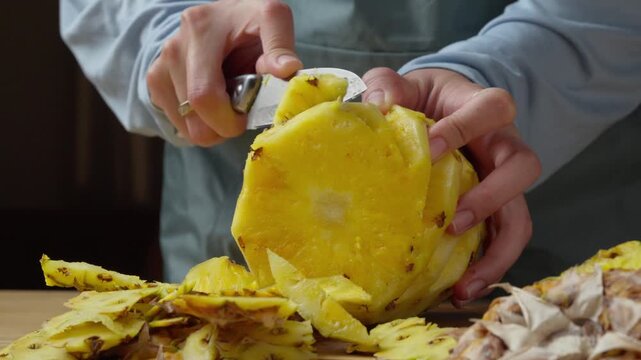 removing the pineapple eyes from a fresh pineapple with a kitchen knife