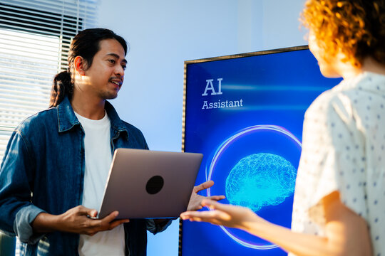 Diverse creative team use Ai Assistant (artificial intelligence assistant) on AI-assisted display for Marketing Data Analyst meeting at office.Coding team,develop programmer,business brainstorming