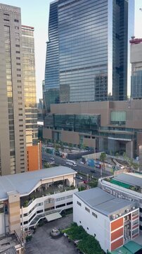 Aerial view of a modern urban landscape featuring tall skyscrapers, commercial buildings, and busy streets in a metropolitan area.