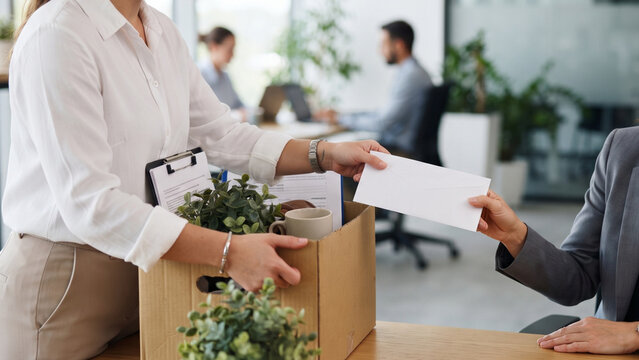 Employee carrying resignation box with personal items in office