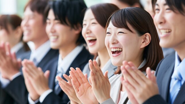 授賞式で心からの喜びを爆発させ笑顔で拍手喝采を送る社員グループ