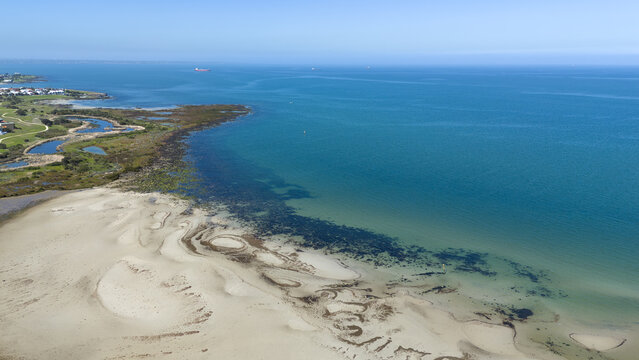 Aerial view of sandy foreshore and shallow sandbanks along Altona Coastal Park near Kororoit Creek mouth into Port Phillip Bay, Melbourne, Victoria, Australia. Environmental and marine conservation