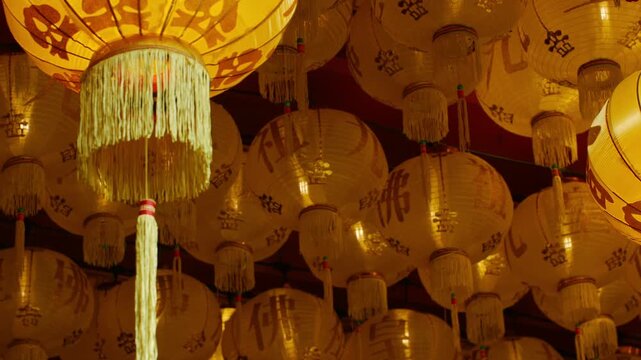 Hundreds of Golden Chinese Lanterns Hanging in Rows at Temple Ceiling