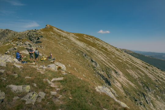 Vast green meadows and rolling hills along the alpine ridge of Parang mountains.