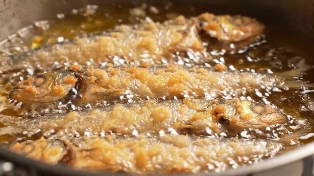 Small Fish Frying and Sizzling in Bubbling Hot Cooking Oil