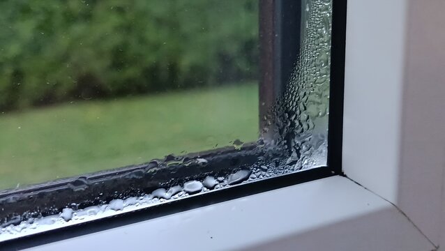 Problem of indoor condensation, crying windows, wet window. Close up of heavy water condensati inside window glass frame. Home dampness, high humidity and ventilation problem concept.