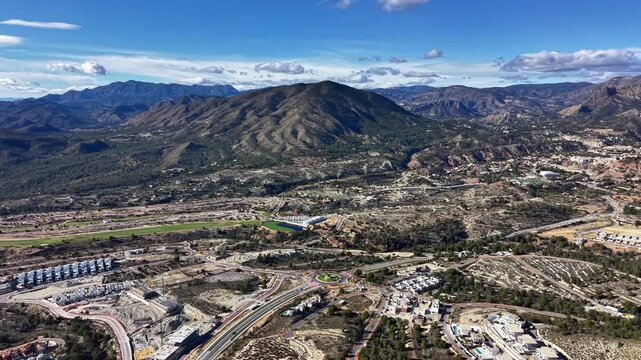 Mountainous Valley With Winding Developments Visible, Green Patches, Winding Roads, Residential Clusters,