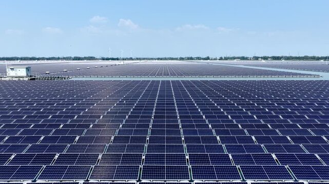 large scale solar photovoltaic panel array on water surface under blue sky