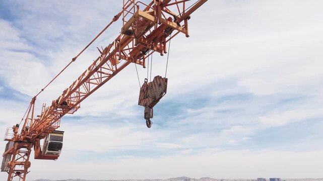 Tower crane against blue sky at high-rise construction site building development