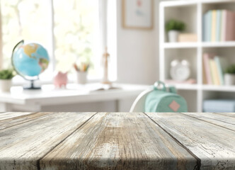 Empty tabletop sits in front of child study room decor, including globe, backpack, and books. Weathered wood surface offers warm classroom style backdrop with soft light and quiet, organized mood. © Agil