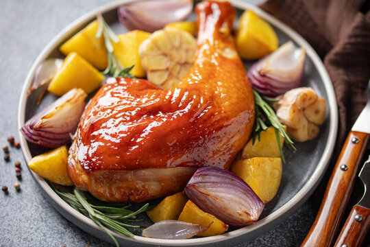 Grilled chicken leg with vegetables on a plate on the table.