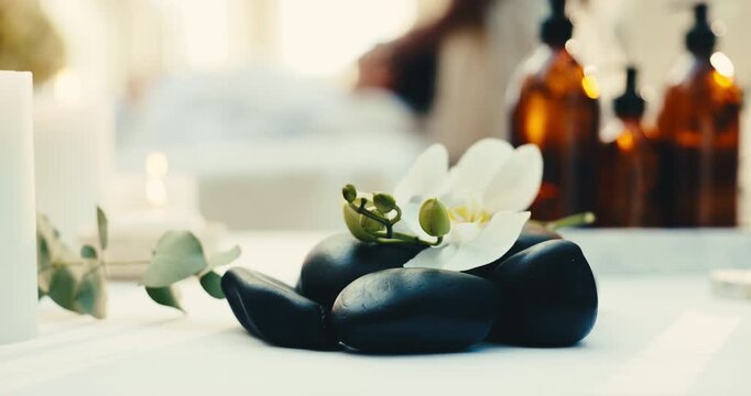 Flowers, rocks and spa for relax, aromatherapy candle or natural wellness for stress relief. Basalt stones, tranquil resort or orchids for therapy with calm, peace or holistic healing at luxury salon