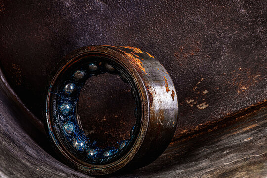 Old industrial ball bearing with grease, raceways and rolling elements, mechanical component, support loads and reduce friction