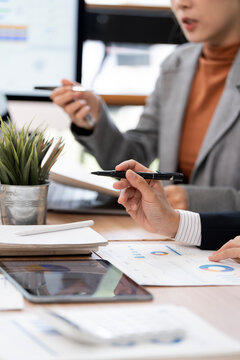 Close Up Business People Holding Pens and Analyzing Financial Reports