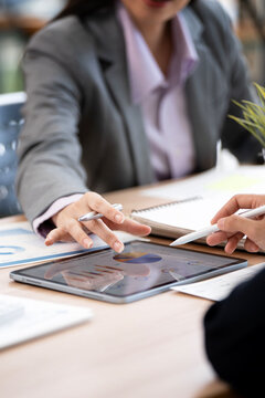 Business People Pointing at Financial Charts on Digital Tablet