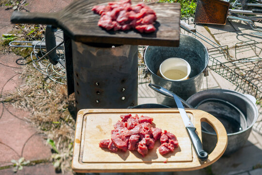 chopping raw meat in an outdoor kitchen