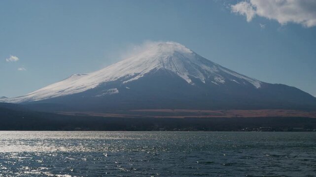 4K Scenic view of Mount Fuji covered with snow and lake in daytime under blue sky, Japan