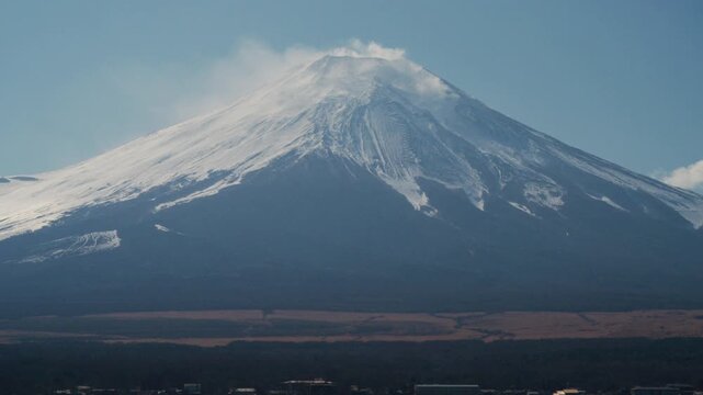 4K Scenic view of Mount Fuji covered with snow and lake in daytime under blue sky, Japan