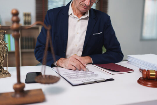 Lawyer reviewing contract in office with legal scales