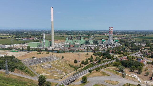 Aerial view of the Tavazzano con Villasco power plant with tall chimneys, industrial buildings, and electrical infrastructure in Lombardia, Italy.
