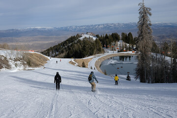 Skiers Heading Down a Wide Run Toward a Mountain Valley in Utah © Taras Vovchuk