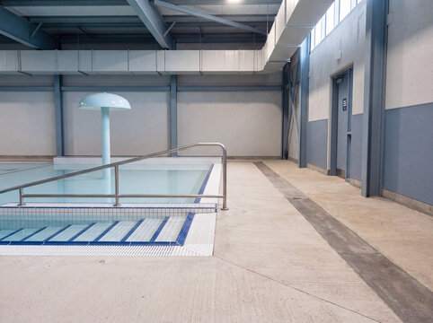Daylit indoor swimming facility: pool lanes beneath a high structural ceiling