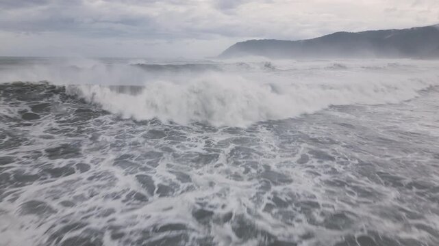 Drone Shot Flying Low Near Large Storm Surge Waves Breaking Ashore