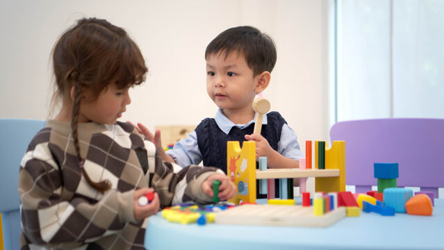 Little boy and girl playing with toys together in the playroom, promoting learning and social interaction