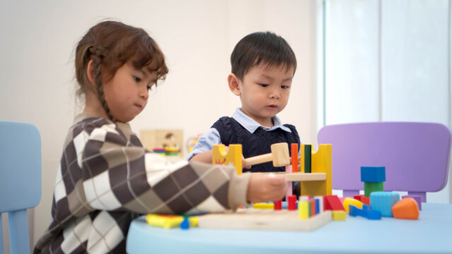 Little boy and girl playing with toys together in the playroom, promoting learning and social interaction